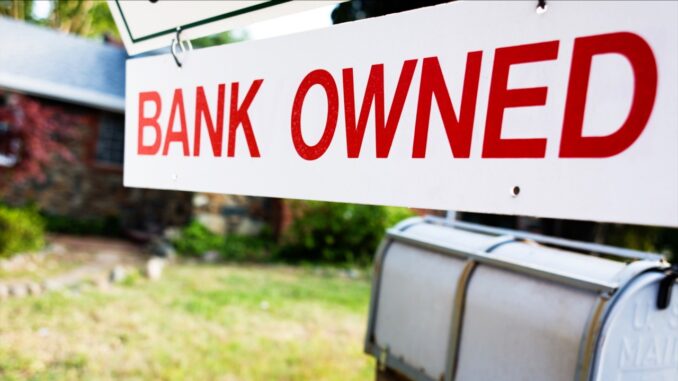 A sign in front of a home that says "Bank Owned"